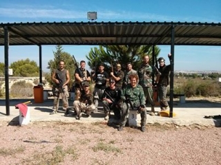 un grupo de chicos en el campo con armas de paintball